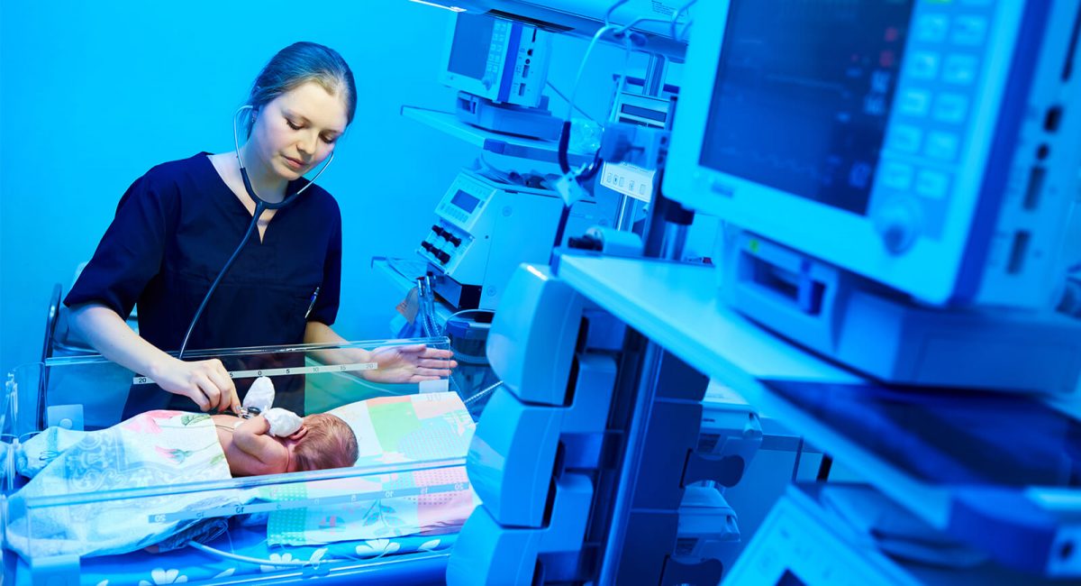 Image of a nurse examining a neonate in the NICU