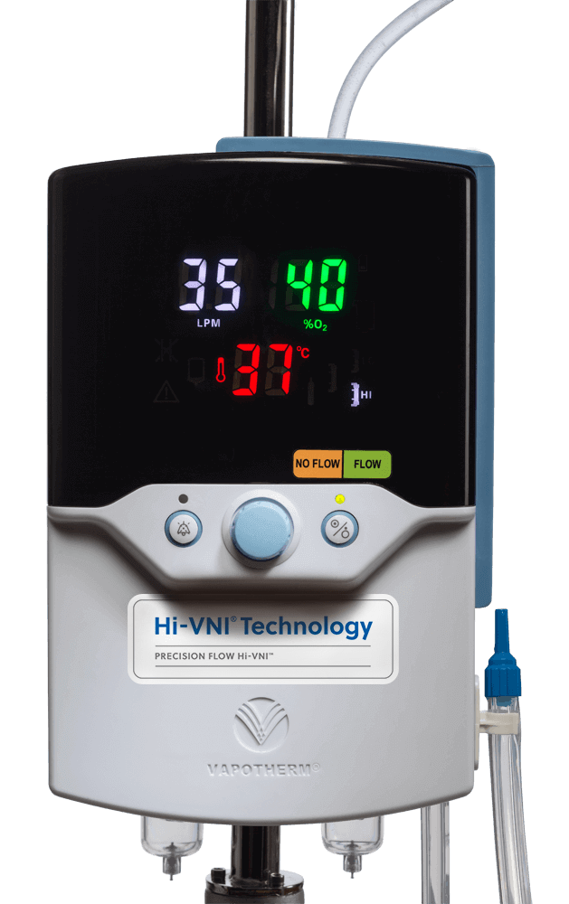 An image of a Vapotherm Precision Flow Hi-VNI unit. It is a boxy unit with a large, easily readable display screen that shows flow rate, temperature, and FiO2. The unit has just 3 buttons.