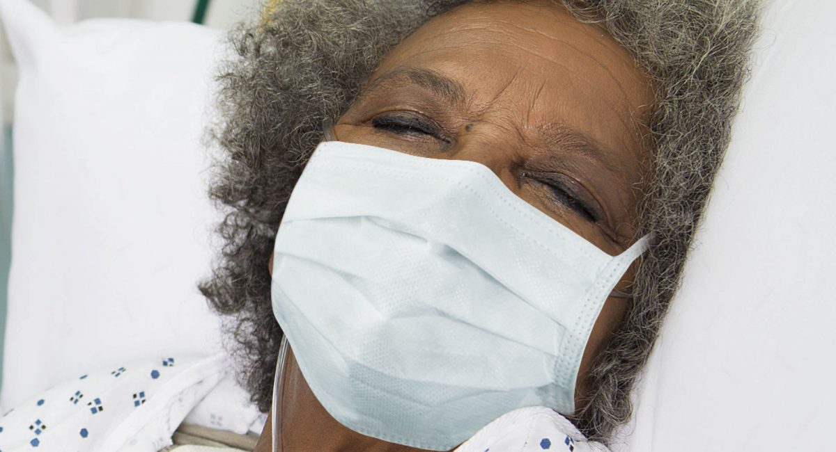 Image of a female patient sleeping with a surgical mask.