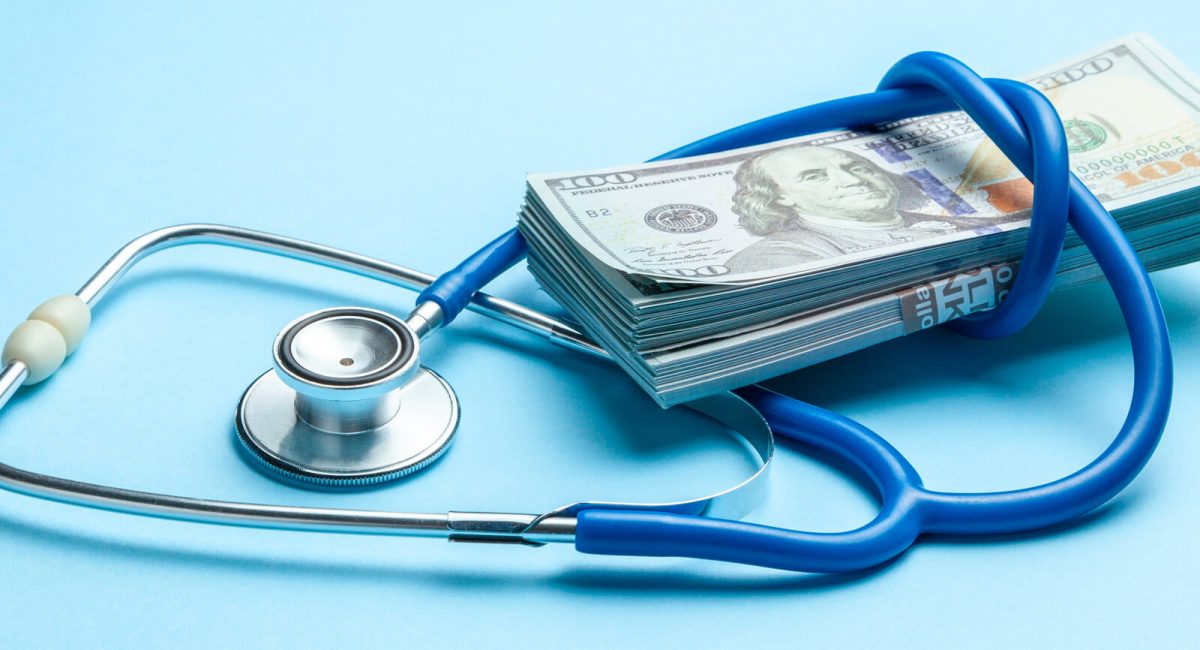 Image of a stack of $100 bills with a stethoscope coiled around it