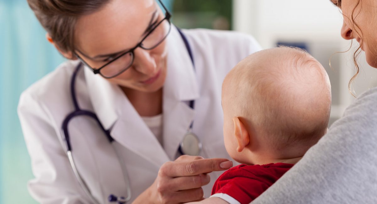 Image of a clinician examining a 1-2 year old patient