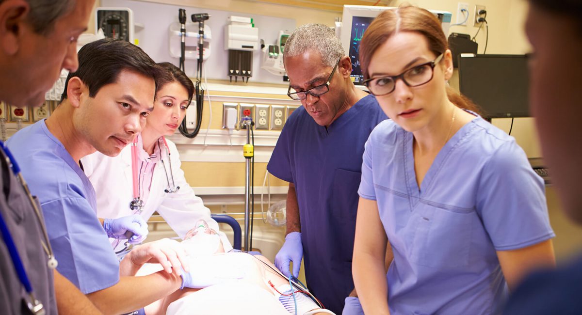 Image of clinicians gathered around what appears to be an operating table