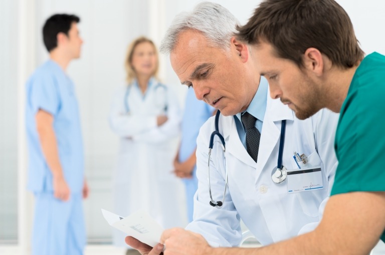 Image of a doctor and nurse going over charts together